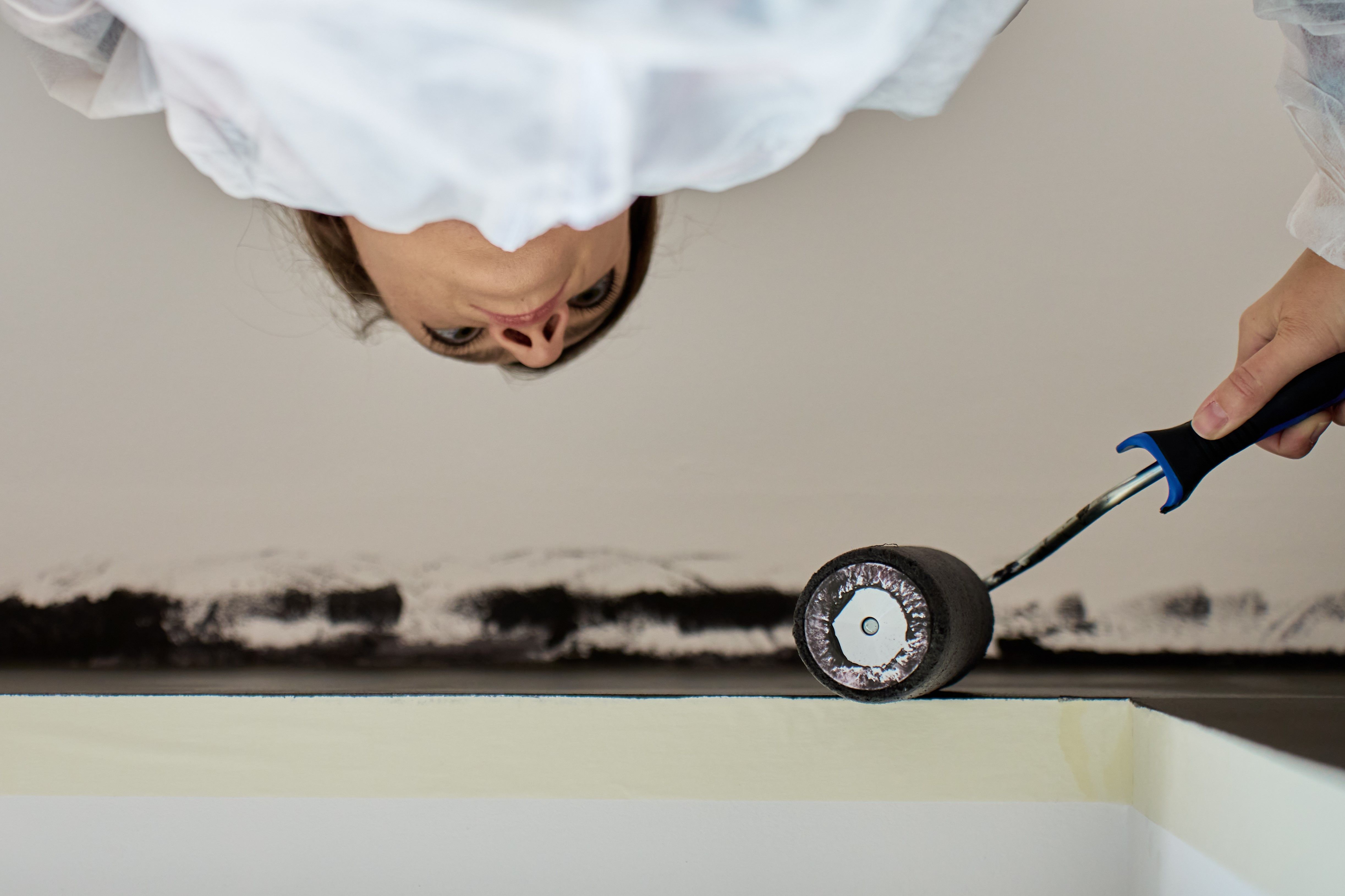 close-up-of-woman-painting-ceiling-and-wall-with-r-2025-06-30-07-41-30-utc